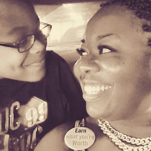 Two people smiling warmly at each other in a close-up shot.