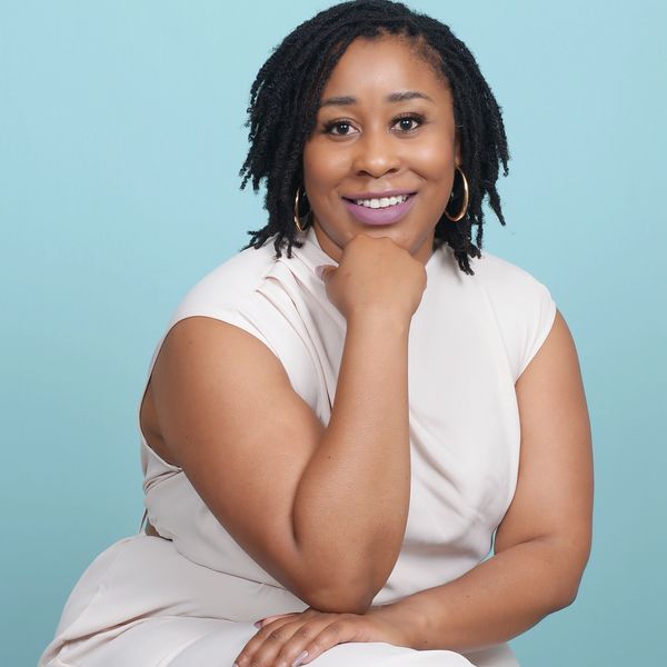 Picture of founder Dr. Shanae S. Jefferies sitting on a chair and smiling.