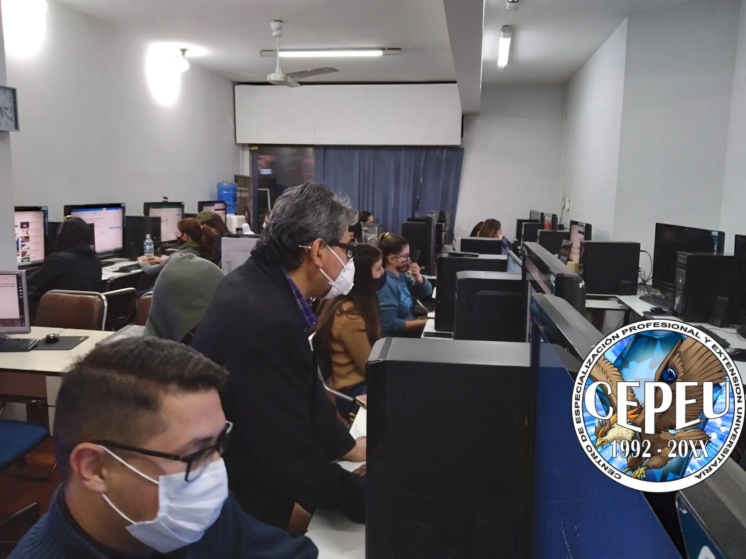 El profesor de computación atendiendo a sus alumno s en la sala de computación. Alumnos estudiando