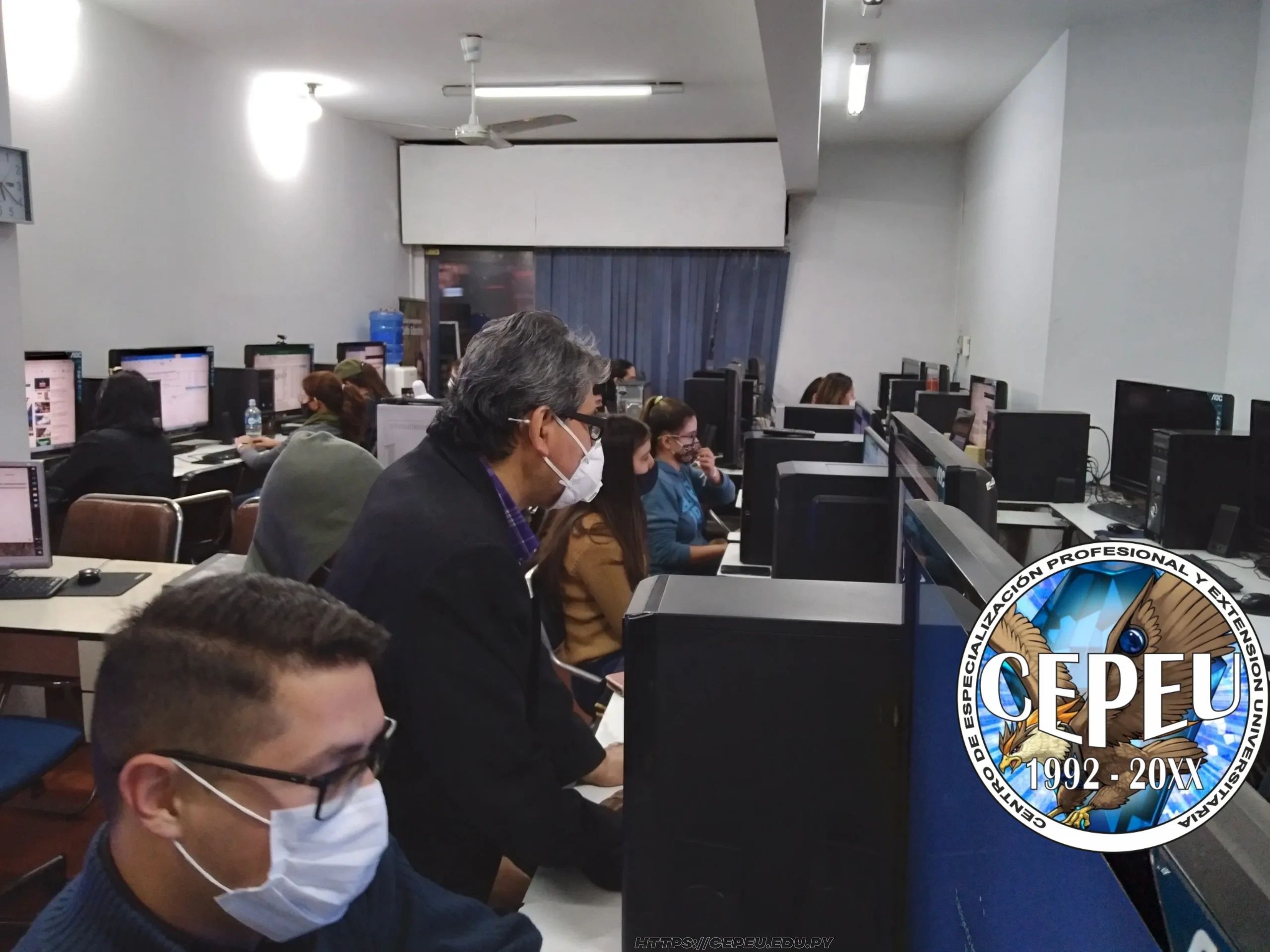 El profesor asistiendo al los alumno se informática