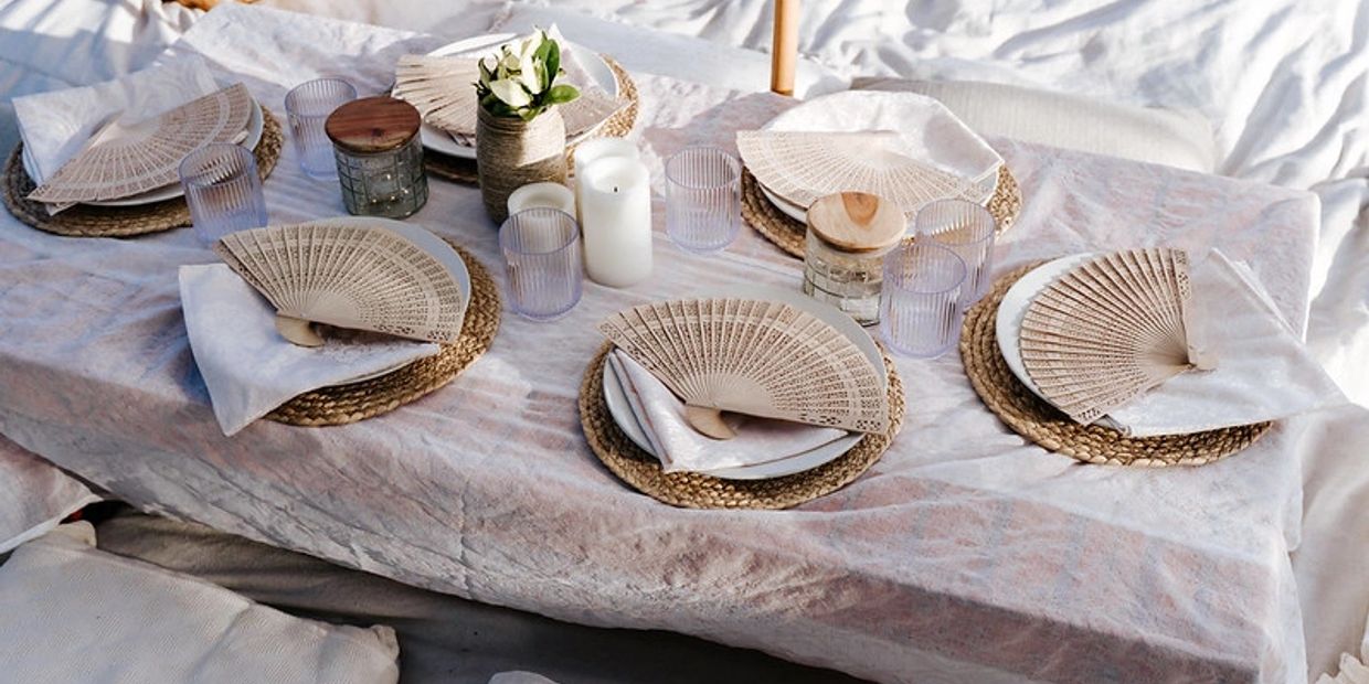 Elegant table setting with woven fans and neutral tones.