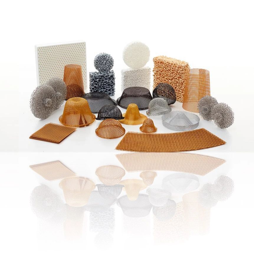 Various porous and mesh materials in different shapes and colors arranged on a reflective surface.