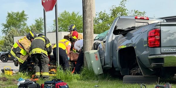 Emergency responders attend to injured person after pickup truck crash at Byron Rd stop sign.