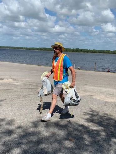 A man walks on a beach with GreenPolly bags during a clean-up event