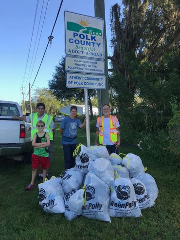 Volunteers standing behind full GreenPolly recycling bags after a clean-up event