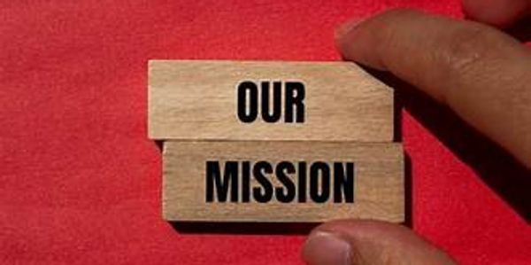 Wooden blocks with 'OUR MISSION' held against a red background.