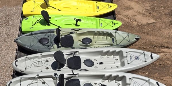 Four kayaks in different colors are lined up.
