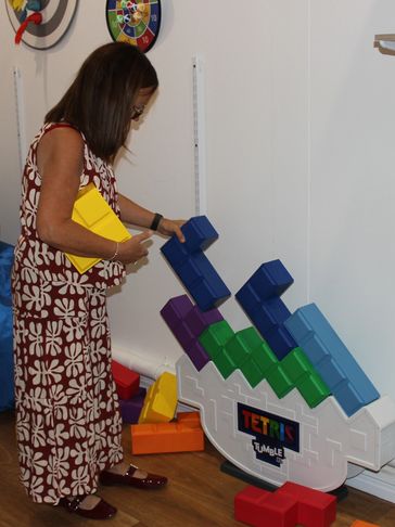 Woman interacting with a Tetris-themed game display.