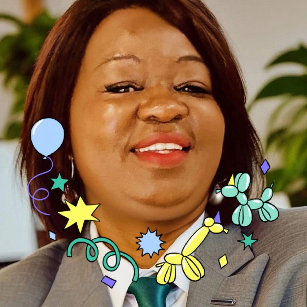 Smiling woman with festive balloon decorations.