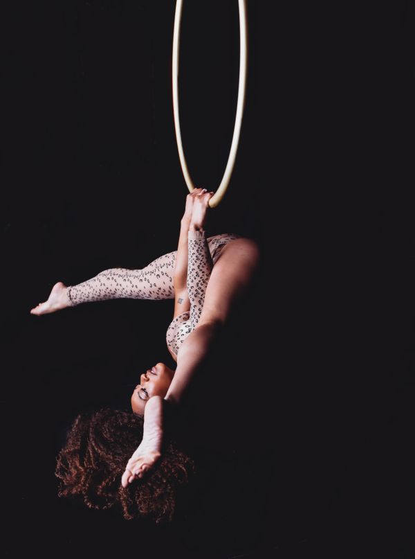 Woman posing at her boudoir session on a lyra hoop.