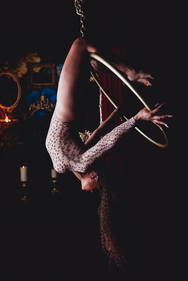 Woman posing on aerial hoop at her boudoir shoot.