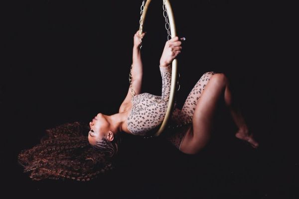 Woman posing on floor with lyra hoop at her boudoir shoot.