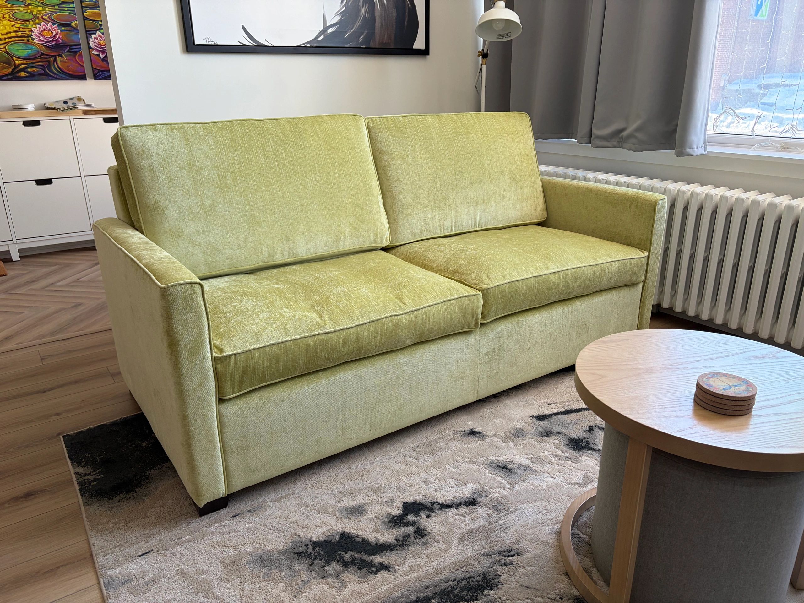 Light green sofa in a cozy living room with a wooden coffee table.