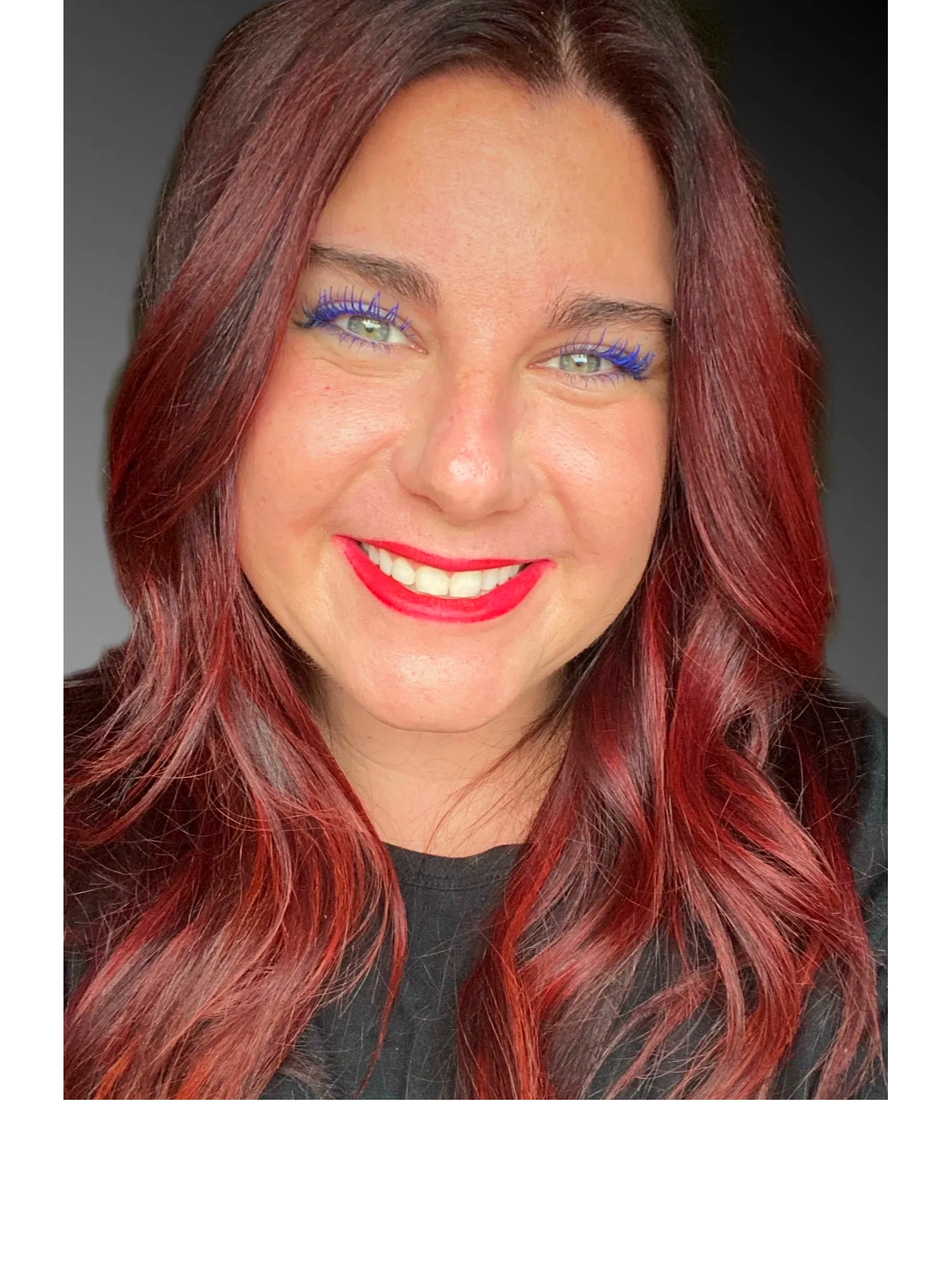 Owner of Between  The Wines Consulting, Kristie smiling with red lips and blue mascara! 