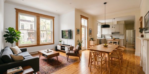 Spacious living and dining area with wooden floors and large windows.