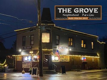 The Grove Neighborhood Pub &amp; Grill illuminated at night with festive lights.
