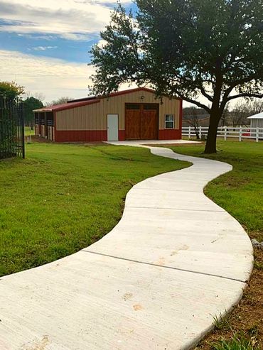 Horse barn with sidewalk in Texas