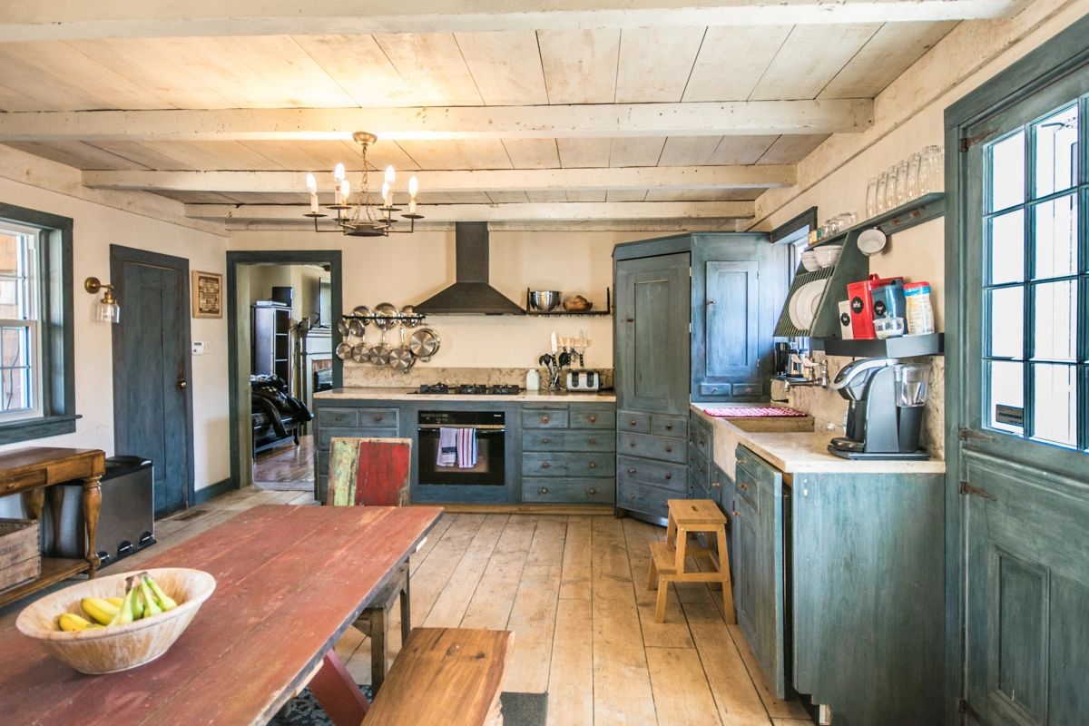 Rustic kitchen with wooden furniture and blue cabinets.