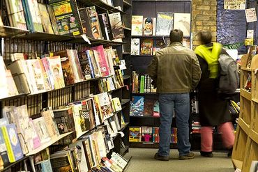 Chicago, Illinois, Quimby's, Customers standing in aisle with books on shelves.