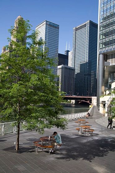 Chicago, Illinois, People on walkway next to Chicago River, with downtown high rises behind.