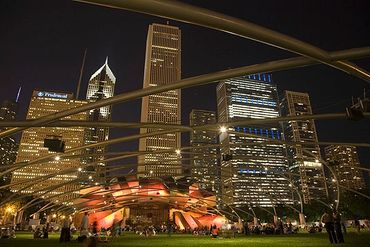 Chicago, Illinois, Millennium Park, Pritzker Pavilion and downtown skyline at night.