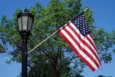 Hinsdale, Illinois, US flag hanging from lamp post on Fourth of July.