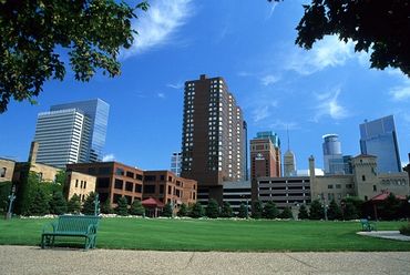 Minneapolis, Minnesota, View of downtown skyline with park bench along sidewalk.