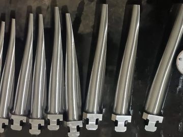 Metal turbine blades aligned with a pressure gauge on a dark surface.