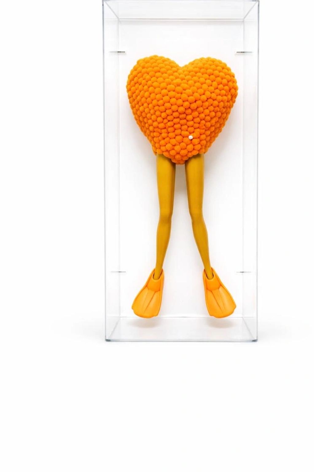Sculpture of legs with flippers and a heart-shaped orange pom-pom cluster.