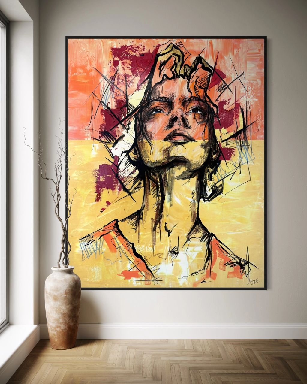 Abstract portret in warme kleuren aan muur.