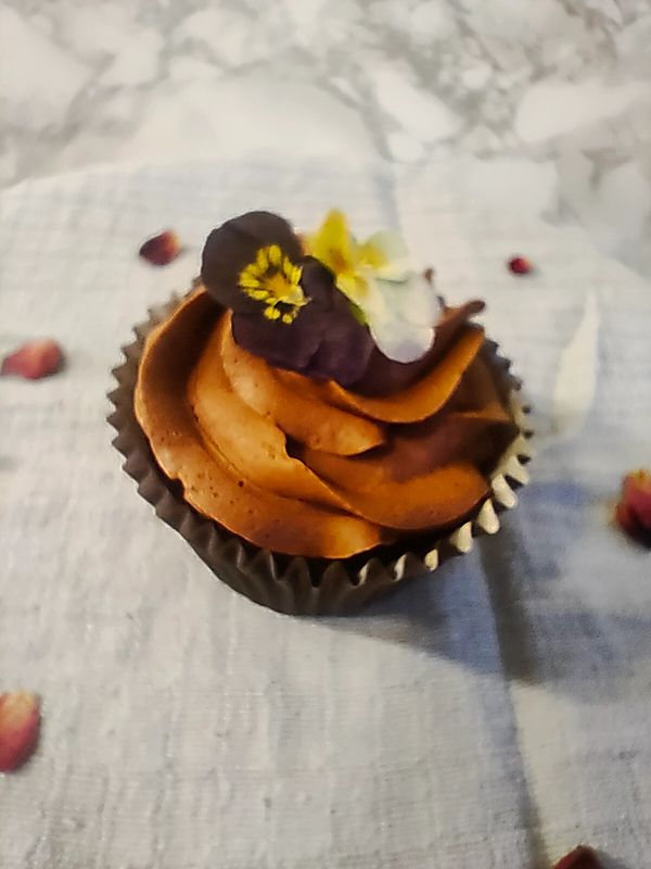 A chocolate cupcake topped with an edible flower