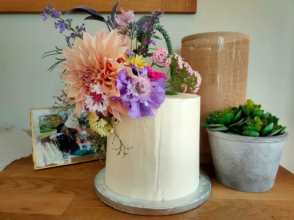 A white cake decorated with a fresh flower arrangement
