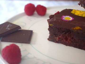 Slice of Raspberry brownie decorated with pressed edible flowers