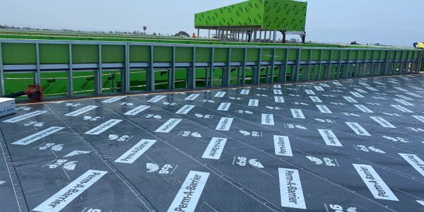 Construction site with waterproofing membrane and green sheathing.