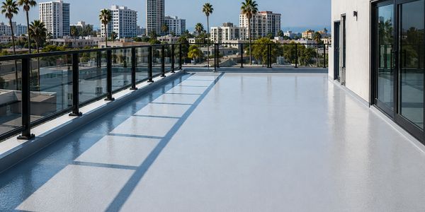 Spacious rooftop terrace with glass railing and city skyline view.