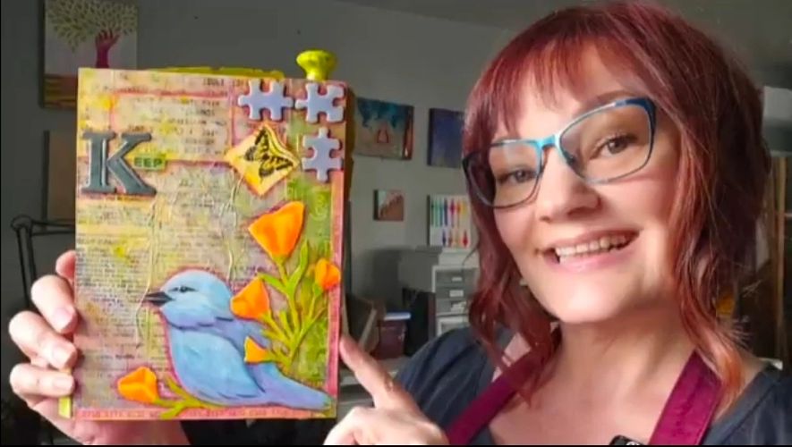 Mindy Griffith holding her mixed-media assemblage artwork, “Keep,” in her studio.