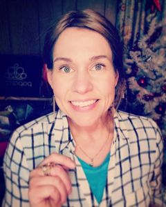 Julia West smiling while wearing plaid. 