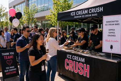People enjoy ice cream at an outdoor Ice Cream Crush stand during a sunny day.