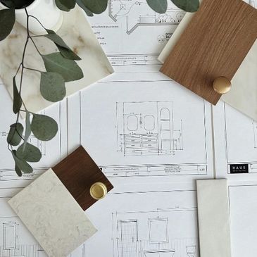 Interior design materials and blueprints arranged on a table.