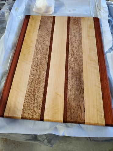 Top view cutting board showcasing Maple and Live Oak with Brazilian Cherry highlights