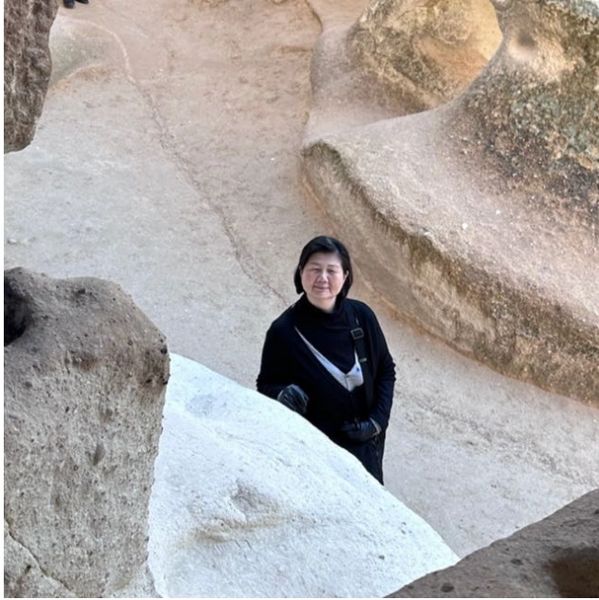 Melissa on her travels, standing between caves