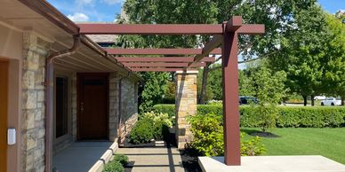 Modern house entrance with wooden pergola.