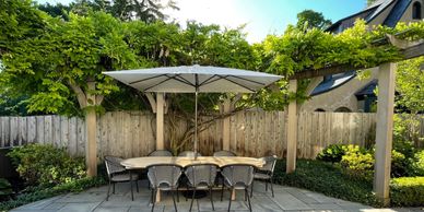 Outdoor dining table with umbrella in a garden.