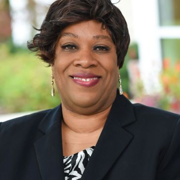 Confident woman in professional attire smiling outdoors.