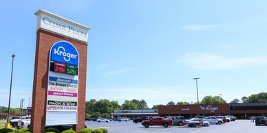Kroger supermarket at Cedar Plaza with a spacious parking lot on a clear day.