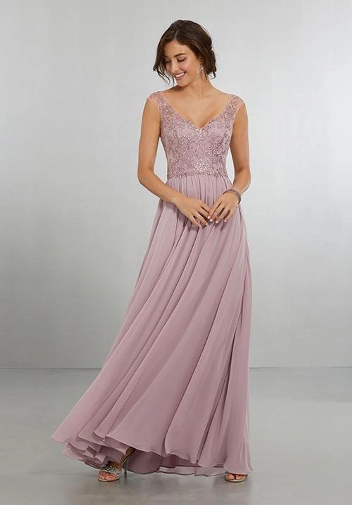 Woman in an elegant dusty pink evening gown with lace bodice