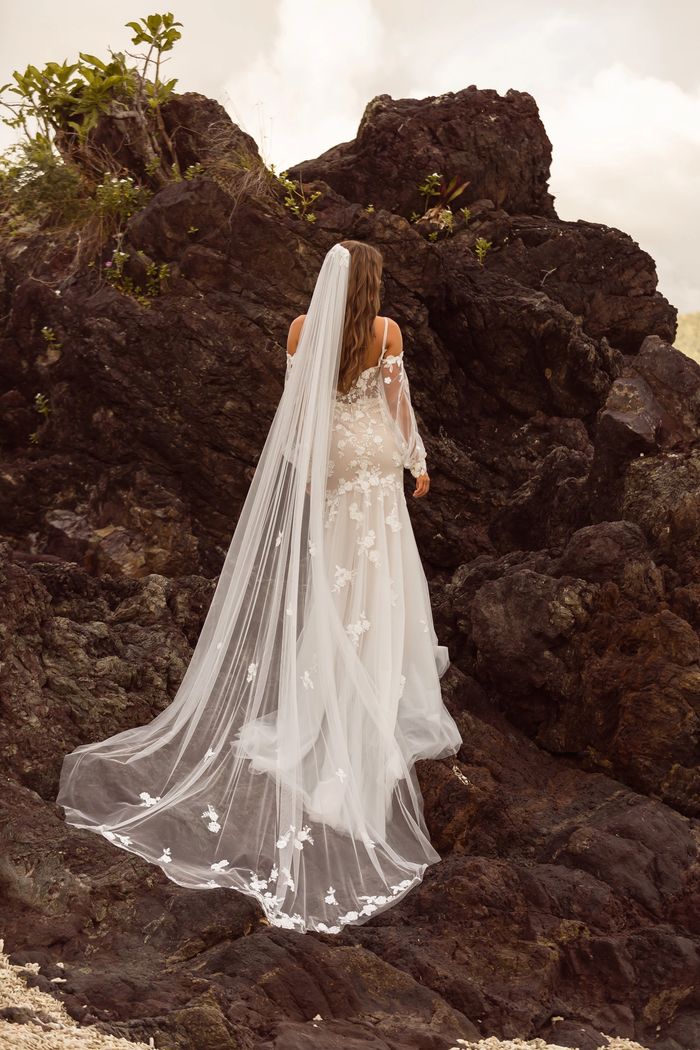 Bride in a flowing veil on rocky terrain