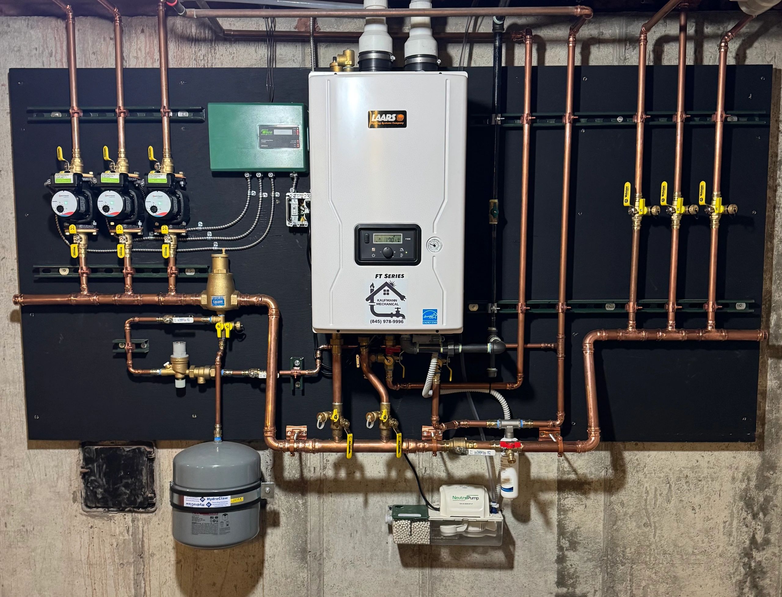 A well-organized plumbing and heating system setup with copper pipes and control units.