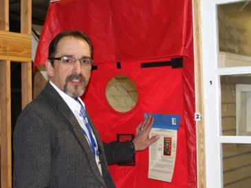 Man demonstrating a red air leakage testing door.