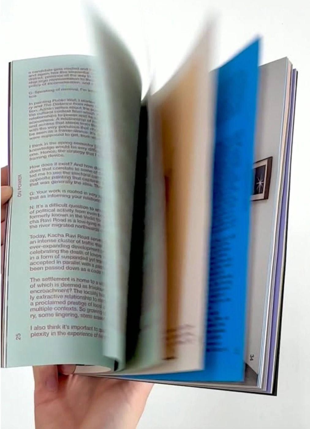 Hand flipping through a book with visible text and colored pages.
